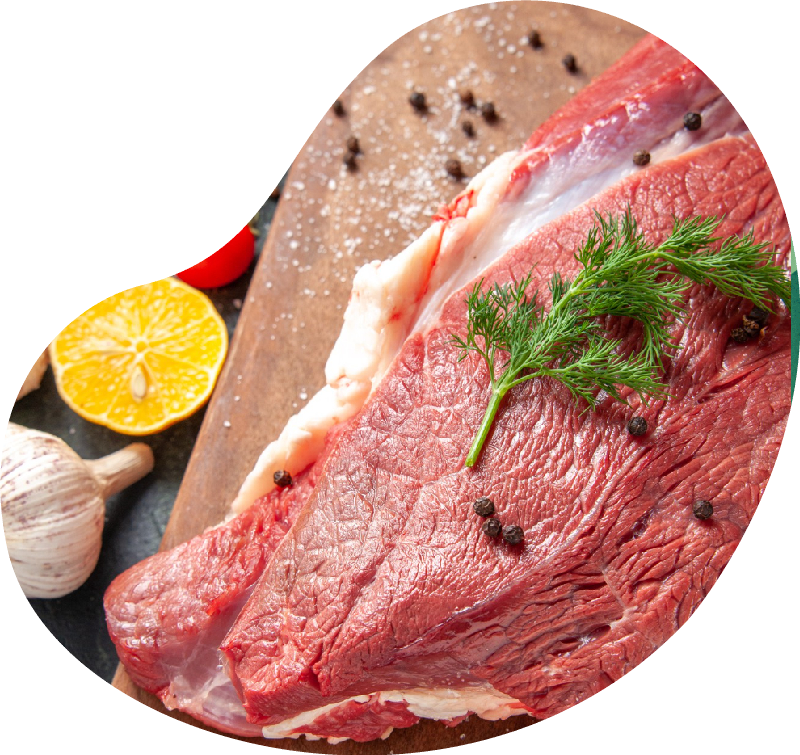 Front close view of fresh raw red meat on wooden cutting board on nude color towel lemon garlic on mixed color background Front close view of fresh raw red meat on wooden cutting board on nude color towel lemon garlic on mixed color background<br />